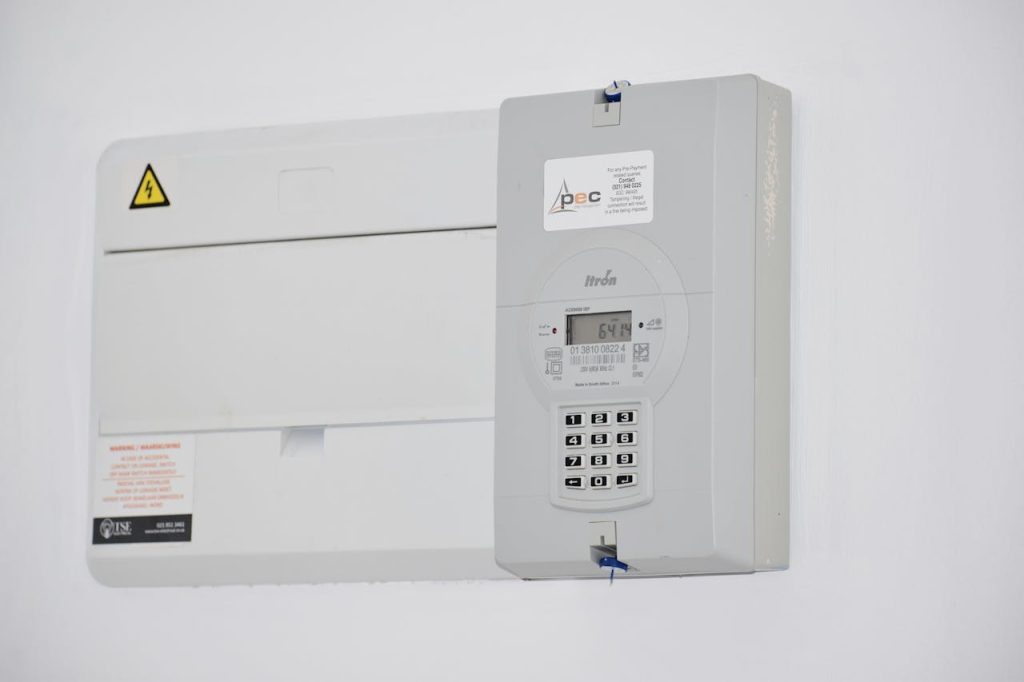 Electrical meter and fuse box on a white wall in Cape Town, South Africa, for energy monitoring or billing.