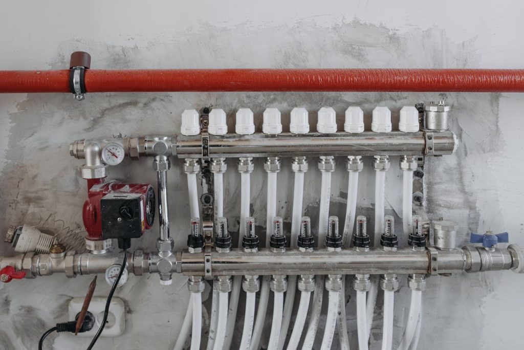 A close-up view of an industrial manifold with pressure gauges and connected steel pipes.